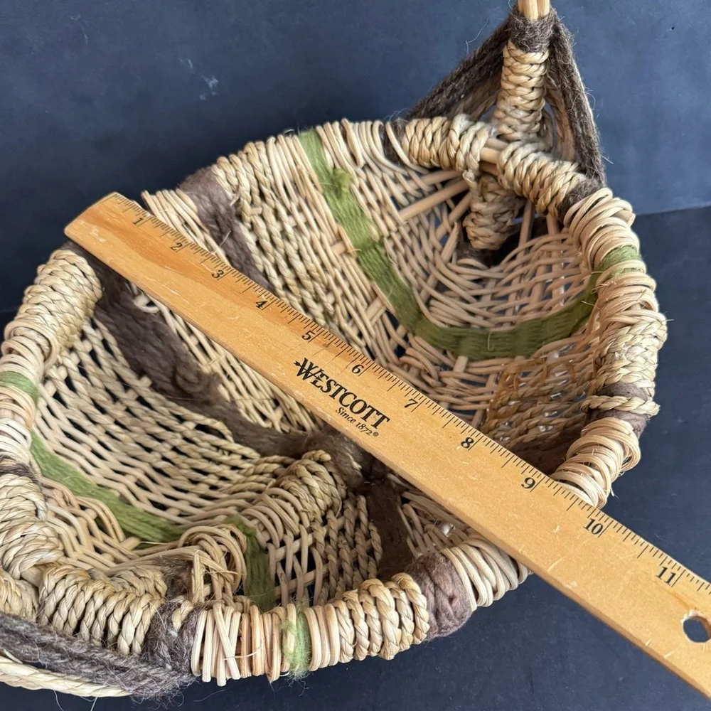 Vintage handwoven basket with brown and green yarn details and eye of God.